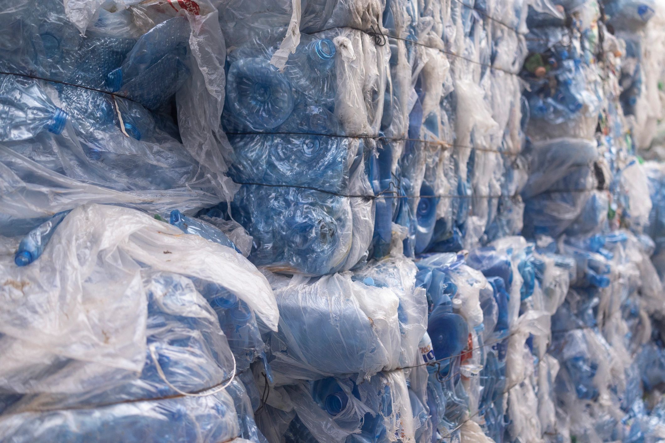 Compressed recyclable plastic bottles stacked at a recycling center